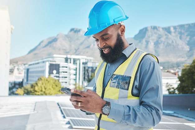 Homme d'ingénierie panneaux solaires et téléphone en économie d'énergie, durabilité et gestion de projet ou communication Électricien ou africain sur une installation mobile écologique et sur le toit de la ville