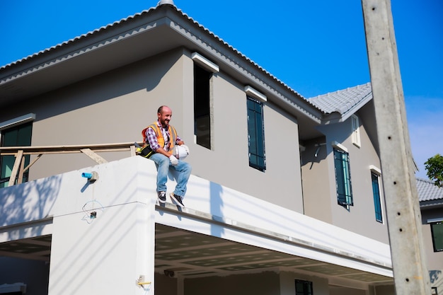 Homme ingénieur hispanique assis et se détendre au deuxième étage de la maison en construction