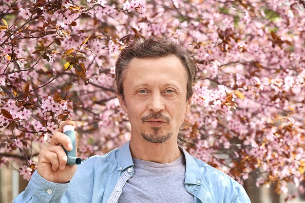 Homme avec inhalateur à l'extérieur le jour du printemps