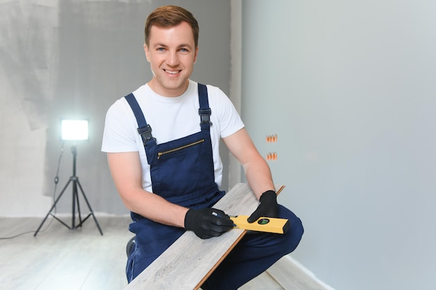 Homme installant un nouveau plancher en bois stratifié