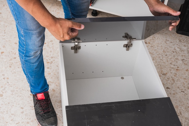 Homme installant les portes d'un meuble de cuisine