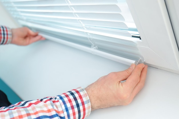 Homme installant des stores à la maison en gros plan