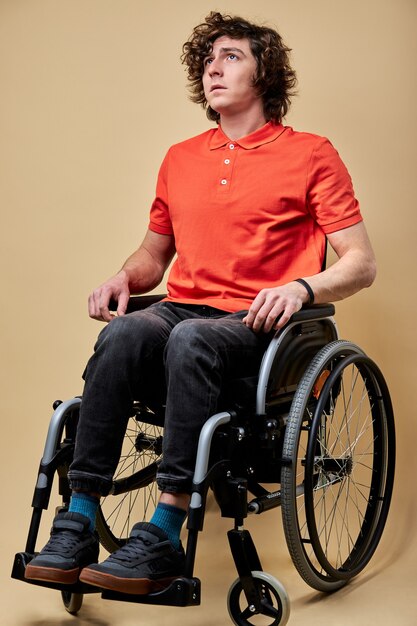 Un homme invalide gravement malade ne peut pas marcher, est assis seul sur un fauteuil roulant, se sentant seul et malheureux, espère un rétablissement. portrait