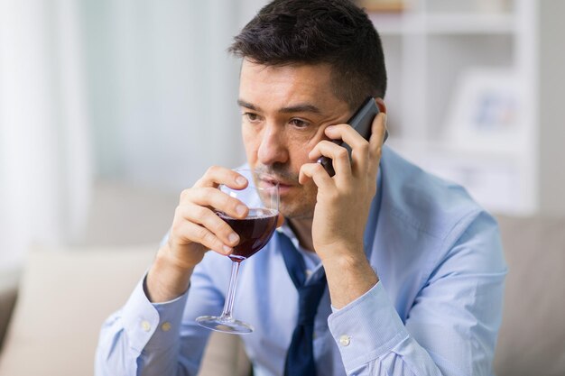 Photo un homme ivre avec de l'alcool appelant sur un smartphone