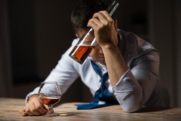 Photo un homme ivre buvant de l'alcool à table la nuit