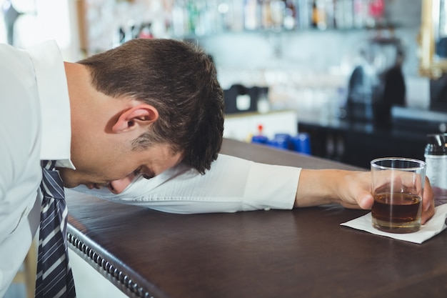 Homme ivre dormant sur un comptoir de bar