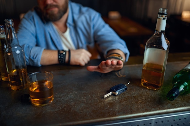 Un homme ivre refuse de conduire sous l'influence de l'alcool au comptoir du bar