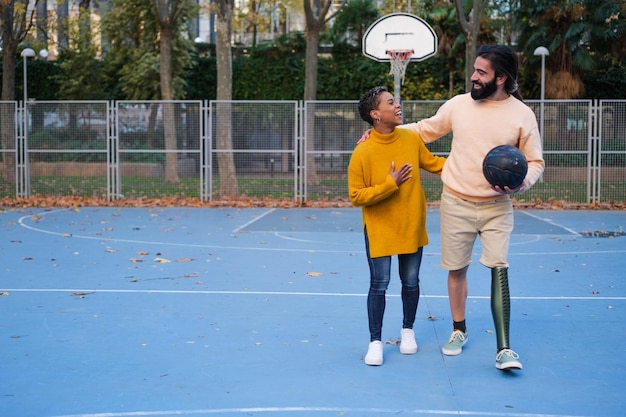 Homme avec une jambe prothétique à côté de la fille après être allé jouer au basket