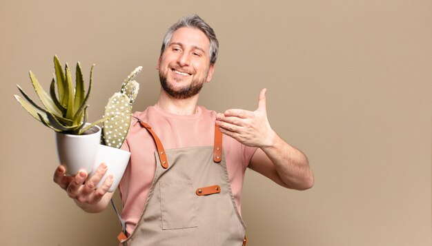 Homme de jardinier d'âge moyen avec cactus