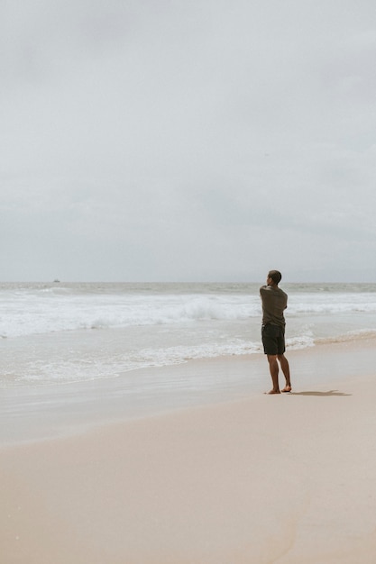 Photo homme jetant une pierre dans la mer