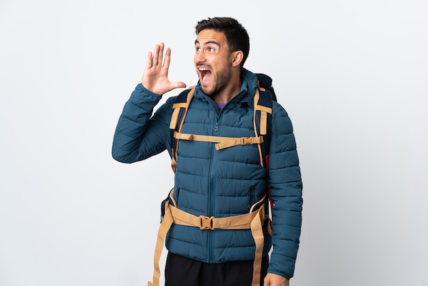 Homme jeune alpiniste avec un gros sac à dos isolé