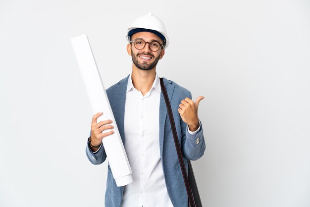 Homme jeune architecte avec casque et tenant des plans isolés