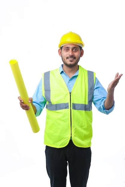 Homme jeune architecte avec casque et tenant des plans à la main. sur fond blanc.