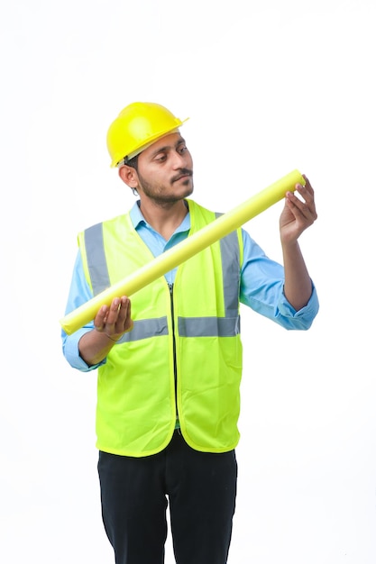 Homme jeune architecte avec casque et tenant des plans à la main. sur fond blanc.