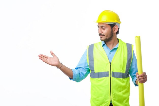 Homme jeune architecte avec casque et tenant des plans à la main. sur fond blanc.