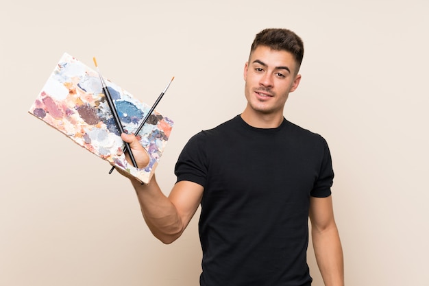 Homme jeune artiste sur fond isolé avec une expression heureuse