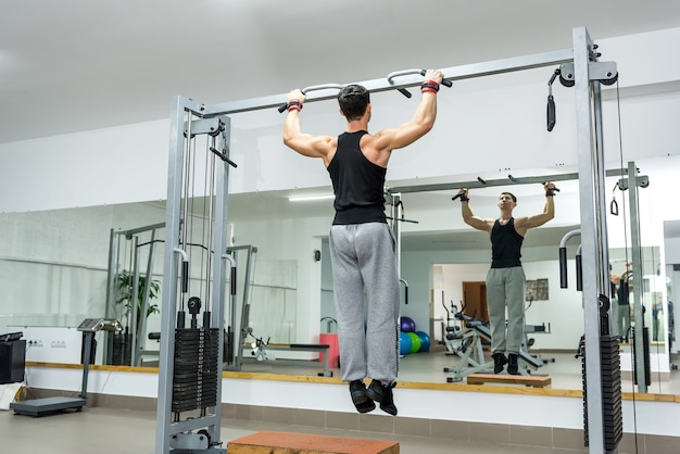 Homme jeune et athlétique faisant des exercices sur la barre transversale