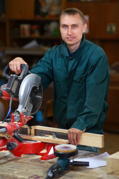 Homme jeune et beau travailleur travaillant sur machine-outil