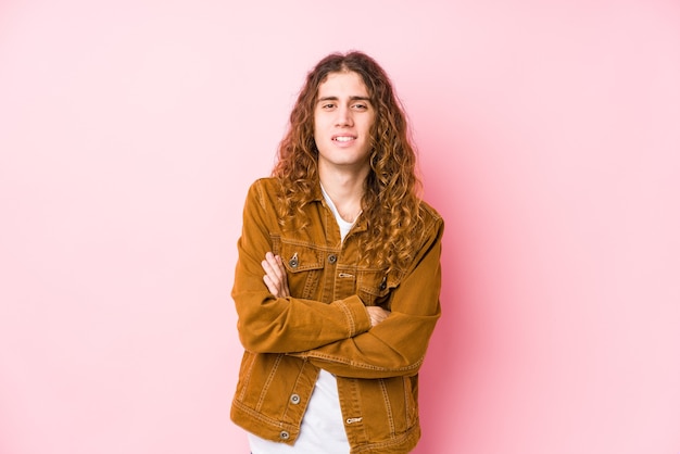 Homme jeune cheveux longs posant isolé en riant et en s'amusant.