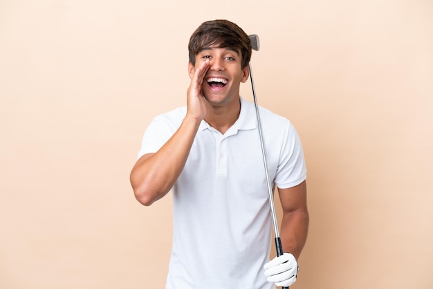 Homme jeune golfeur joueur isolé sur fond ocre criant avec la bouche grande ouverte