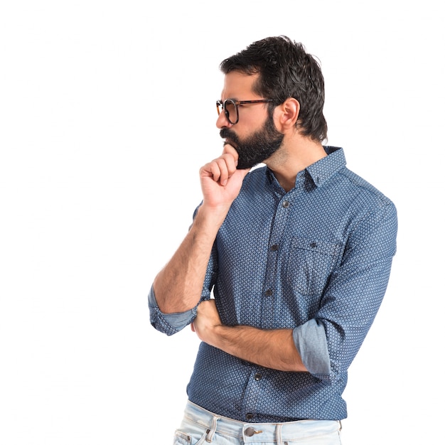 Homme jeune hipster réfléchissant sur fond blanc