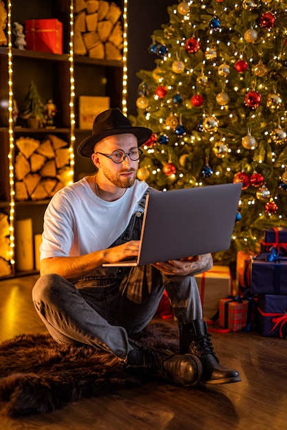 Homme jeune hipster travaillant à domicile pendant Noël