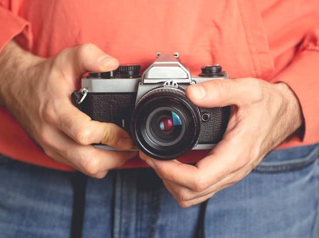 Homme jeune hipster avec vieux appareil photo vintage.