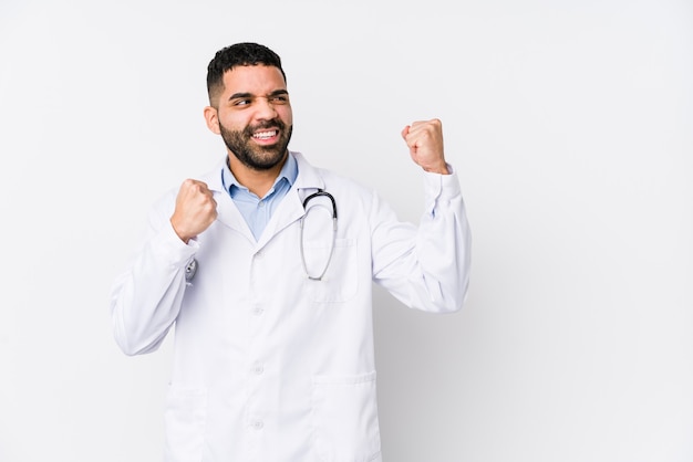 Homme jeune médecin arabe isolé levant le poing après une victoire, concept gagnant.