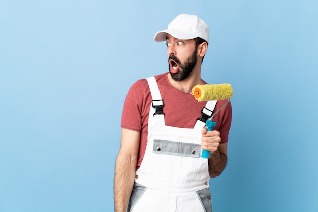 Photo homme jeune peintre sur fond bleu isolé