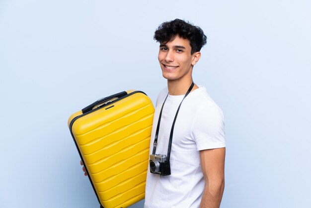 Homme jeune voyageur sur mur isolé