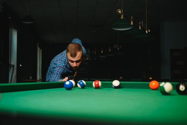 Homme jouant au billard dans un club