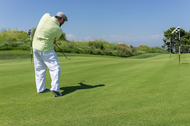 Homme jouant au golf au club