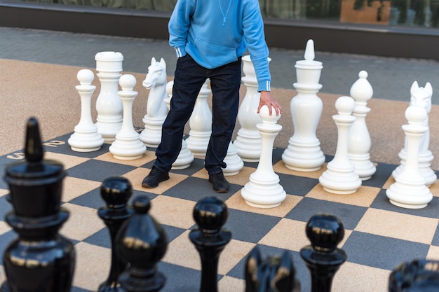 Homme jouant aux échecs gigantesques à l'extérieur