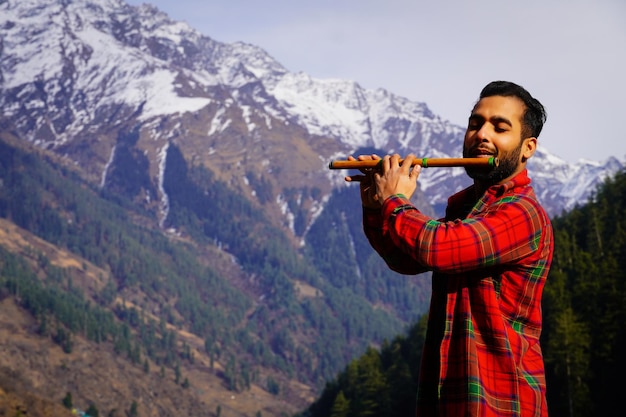 Homme jouant de la flûte indienne dans les montagnes