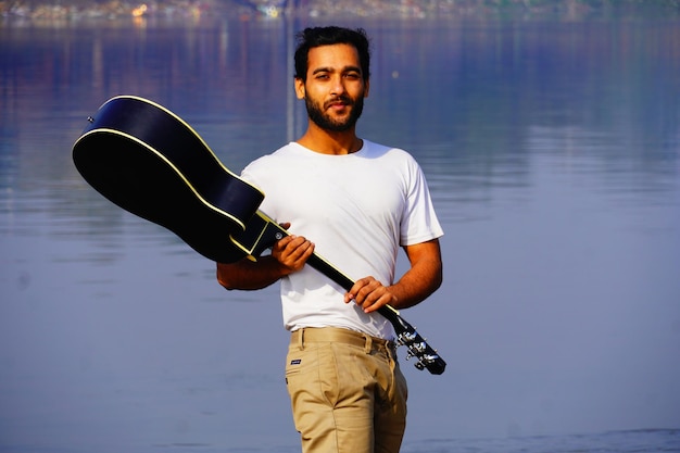 Homme jouant de la guitare acoustique sur le bateau