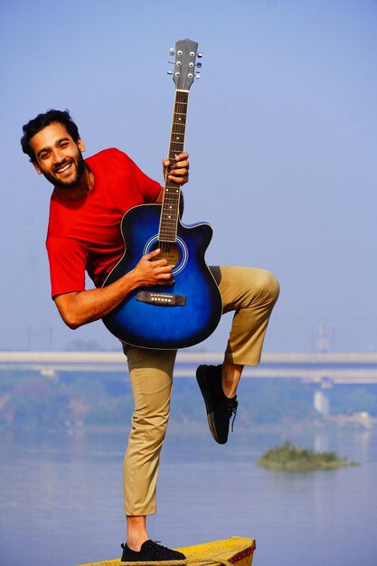 Homme jouant de la guitare acoustique sur le bateau