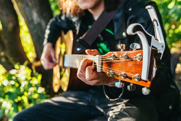 Homme jouant de la guitare acoustique et jouant des accords agrandi