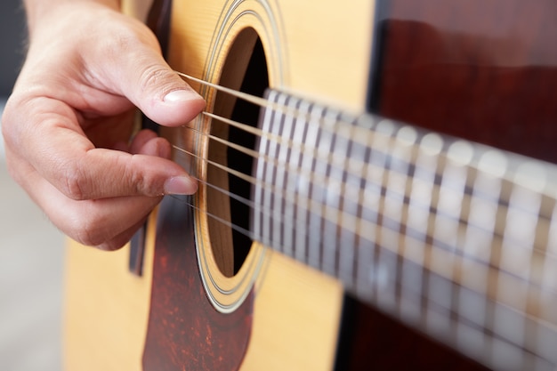 Homme jouant de la guitare acoustique