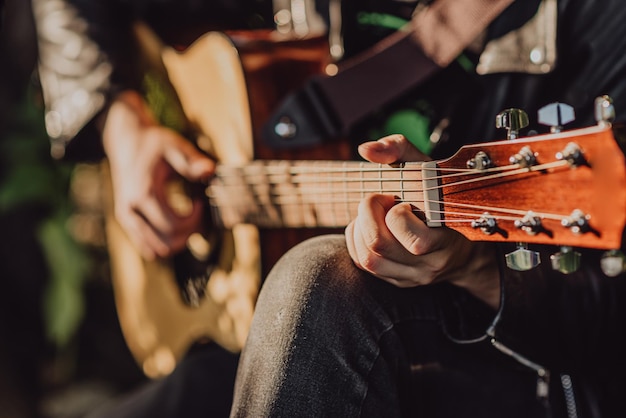 Homme jouant de la guitare dans la nature par une journée ensoleillée