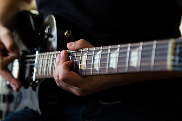 Homme jouant sur la guitare électrique noire