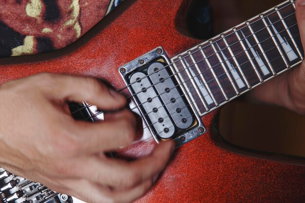 Photo homme jouant de la guitare électrique vue rapprochée très faible profondeur de champ image effet cinématographique appliqué