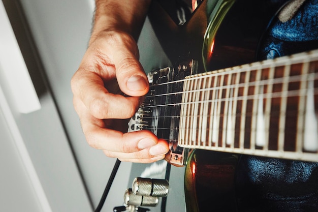 Photo homme jouant de la guitare électrique vue rapprochée très faible profondeur de champ image effet cinématographique appliqué