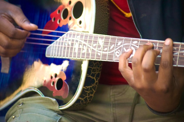 Un homme jouant de la guitare avec un motif floral sur le côté.