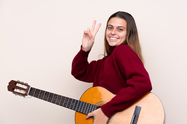 homme jouant de la guitare sur un mur isolé