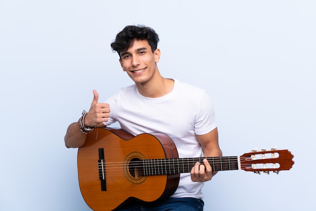 Homme jouant de la guitare sur un mur isolé