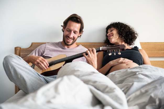 Homme jouant de la guitare pour femme enceinte