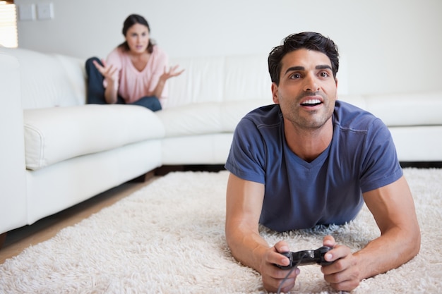 Homme jouant à des jeux vidéo pendant que son fiancé se fâche contre lui