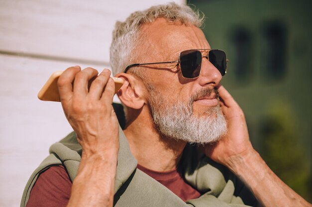 Homme jouant un message vocal sur son téléphone portable