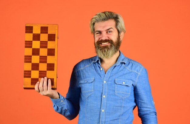 Photo l'homme joue au jeu d'échecs. concept de stratégie et de tactique d'entreprise. stratégie avec des figures d'échecs. bataille d'échecs et victoire. concept de jeu de société. idées de compétition et de stratégie. concours de défis commerciaux.