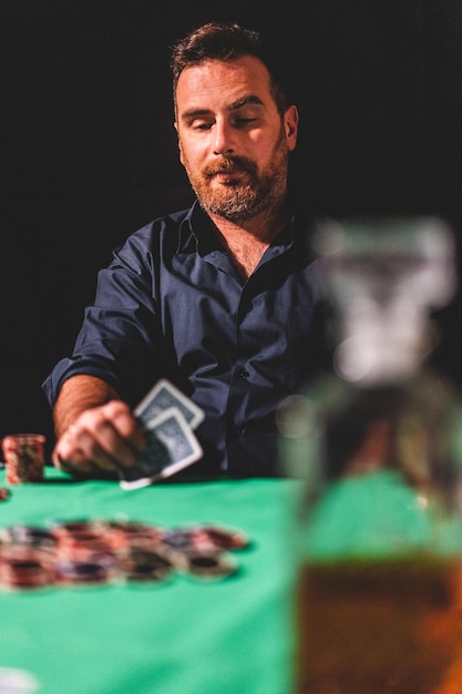 Photo un homme joue au poker sur un fond noir.